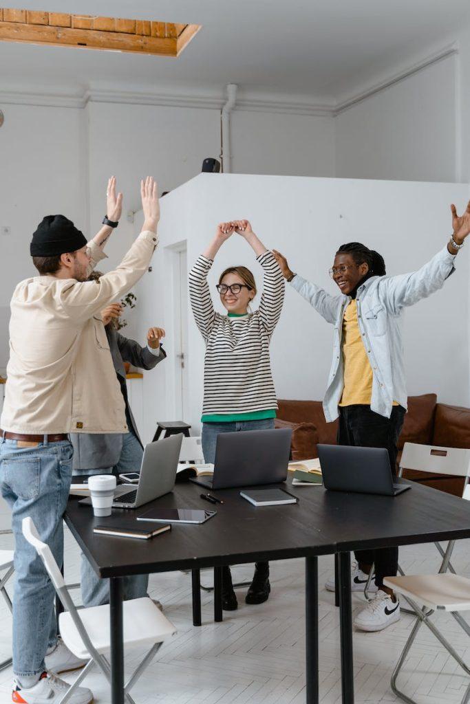 a group of people celebrating together at work, small business,