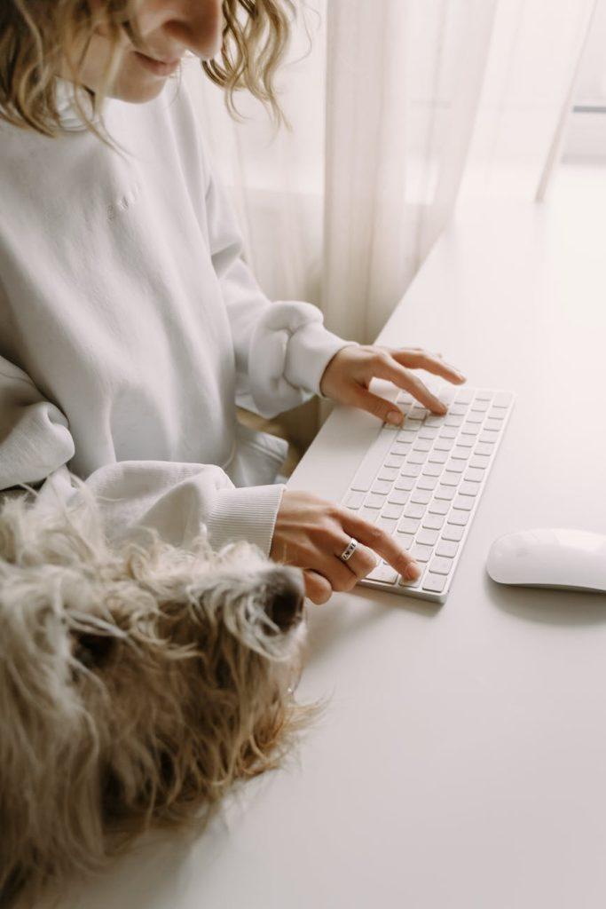 person in white long sleeve typing on a keyboard